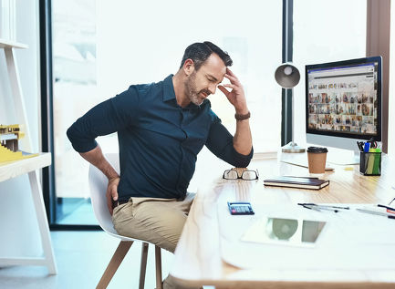 Man at desk visibly in pain